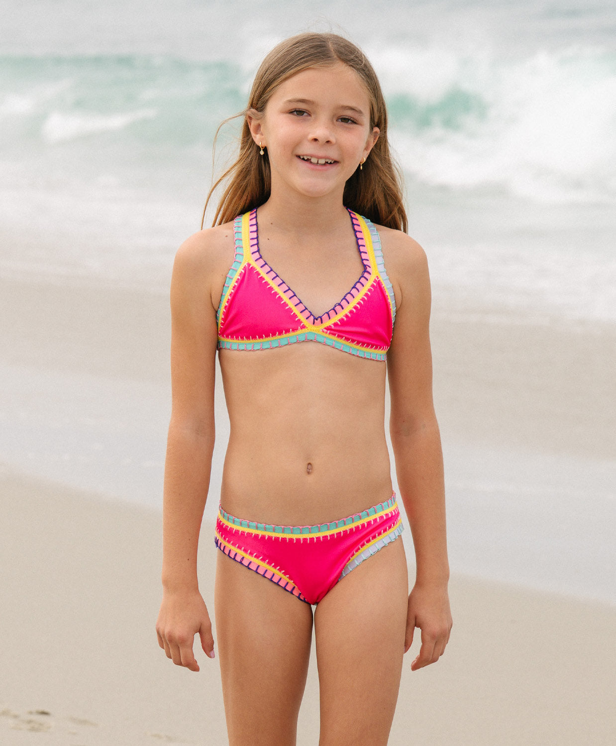 Meisje in felroze PQ Swim bikini op het strand